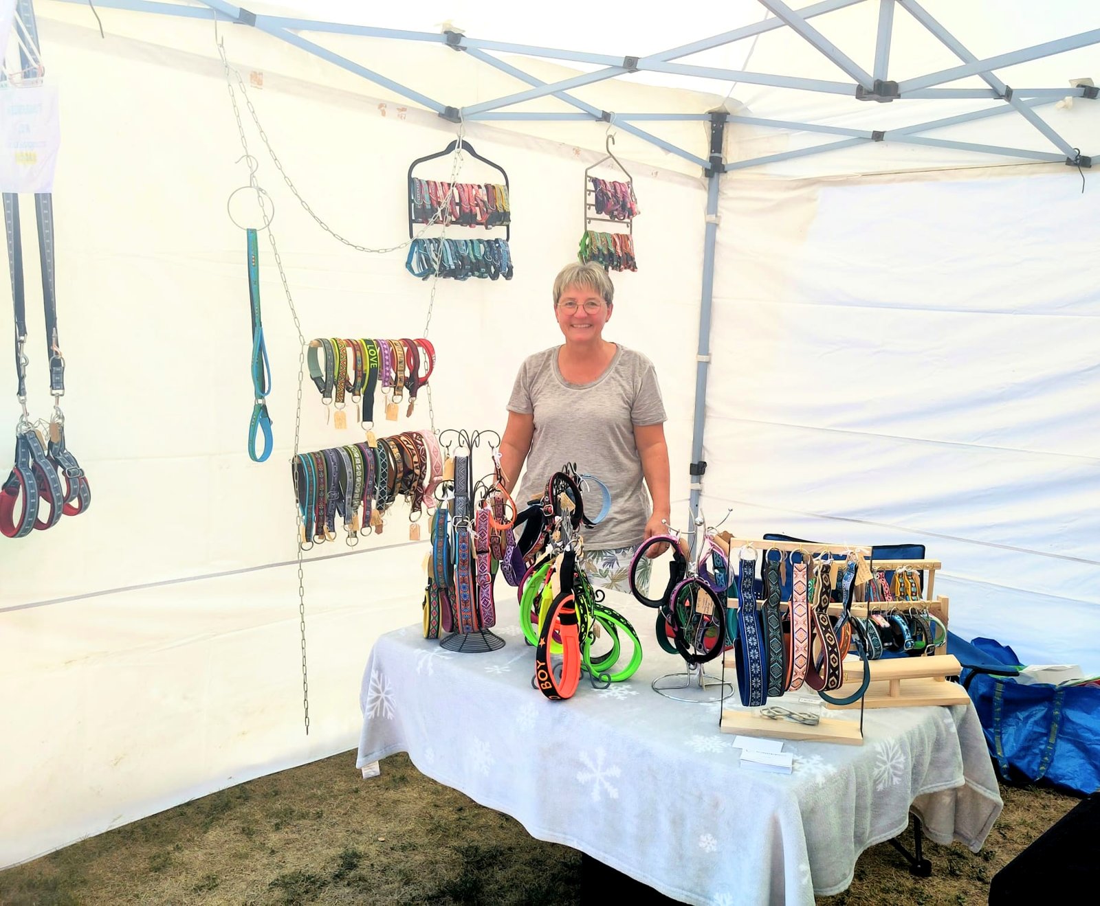 Anita am Stand der Halsbandwerkstatt im Zelt am Thurland Jumpers Cup, umgeben von aufgehängten Hundehalsbändern und Leinen