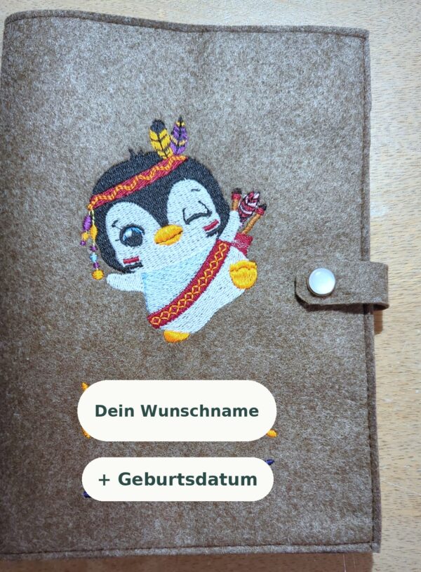 Gesundheitsheft-Hülle aus braunem Filz mit gesticktem Pinguin-Motiv und Druckknopf – Beispiel aus der Werkstatt